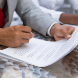 un jeune homme en train de signer son contrat de travail