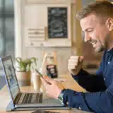 Un freelanceur travaille dans un café avec une tablette et un ordinateur portable.