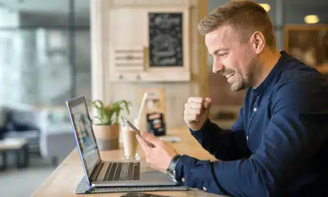 Un freelanceur travaille dans un café avec une tablette et un ordinateur portable.